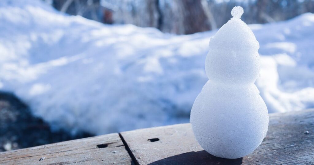 雪景色の中にかわいい雪だるまがいる様子