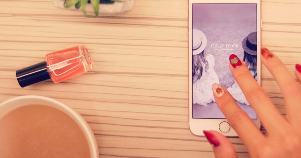 スマホを片手に調べ物をしている女性の様子。