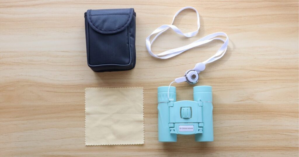 クロスロード双眼鏡と付属品のネックストラップ、専用ケース、レンズクリーナーを並べた写真