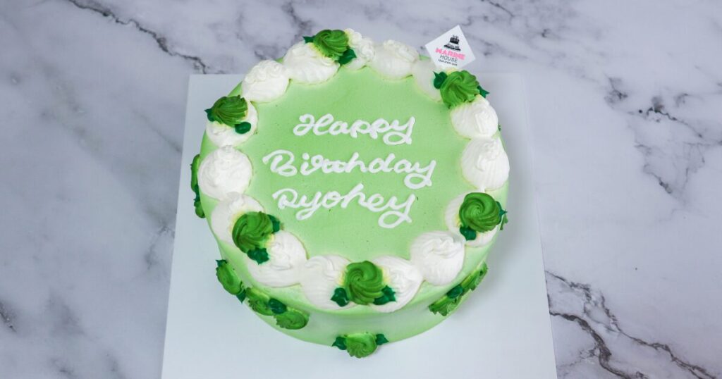 実際に届いたケーキの写真:真上から。黄緑の上品なベースに、クリームで形作った緑色のバラがあしらわれている