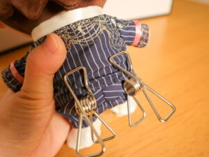 画像イメージ：ぬいの足元にステンレスピンチを挟んで立たせようとしている写真
