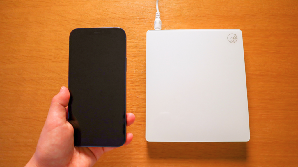 画像イメージ:CDレコ/ラクレコ+などのスマホ用CDレコーダーにCDをセットし、iPhoneで取り込んでいる実物写真