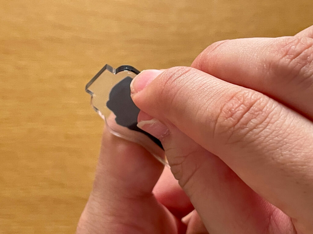 自作アクスタの縁を爪で引っ掻いている様子
